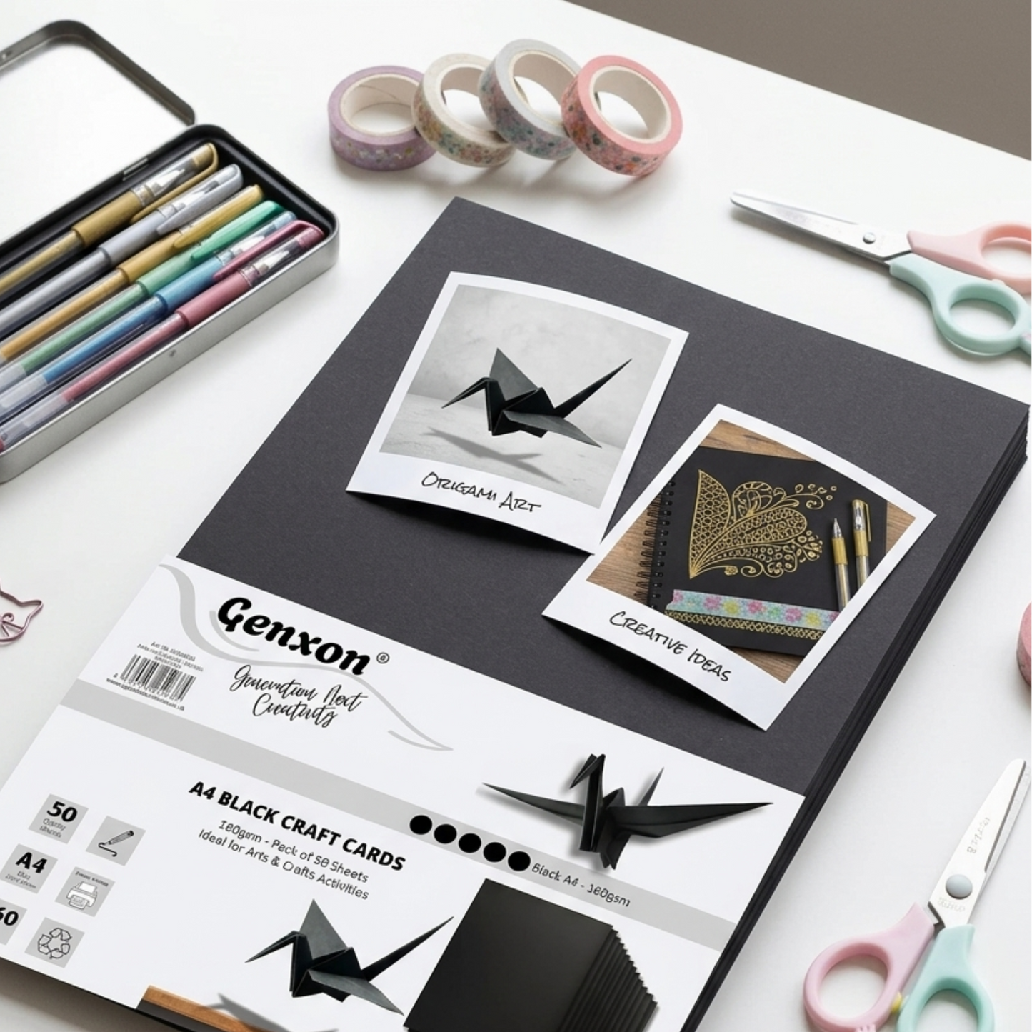 Black craft cards with origami designs on a white surface with stationery items.