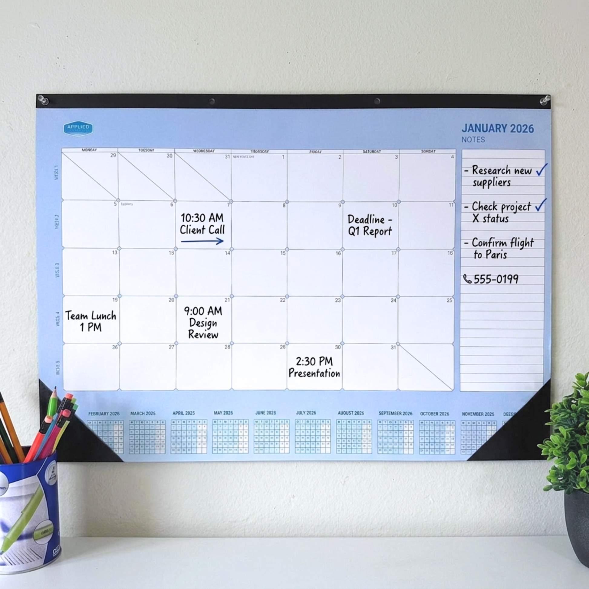 Wall-mounted calendar 2026 with a blue border and whiteboard surface, showing a schedule and notes.
