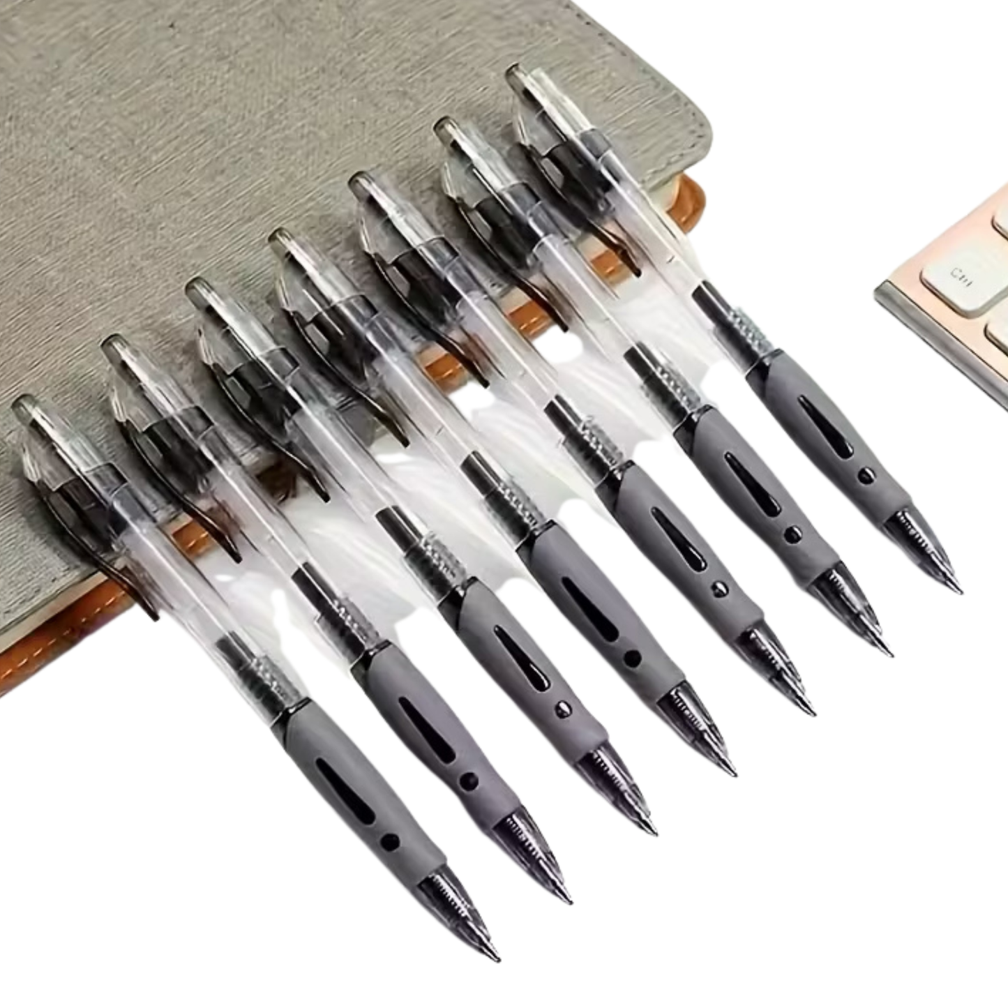 Set of pens with transparent and metallic accents on a neutral background