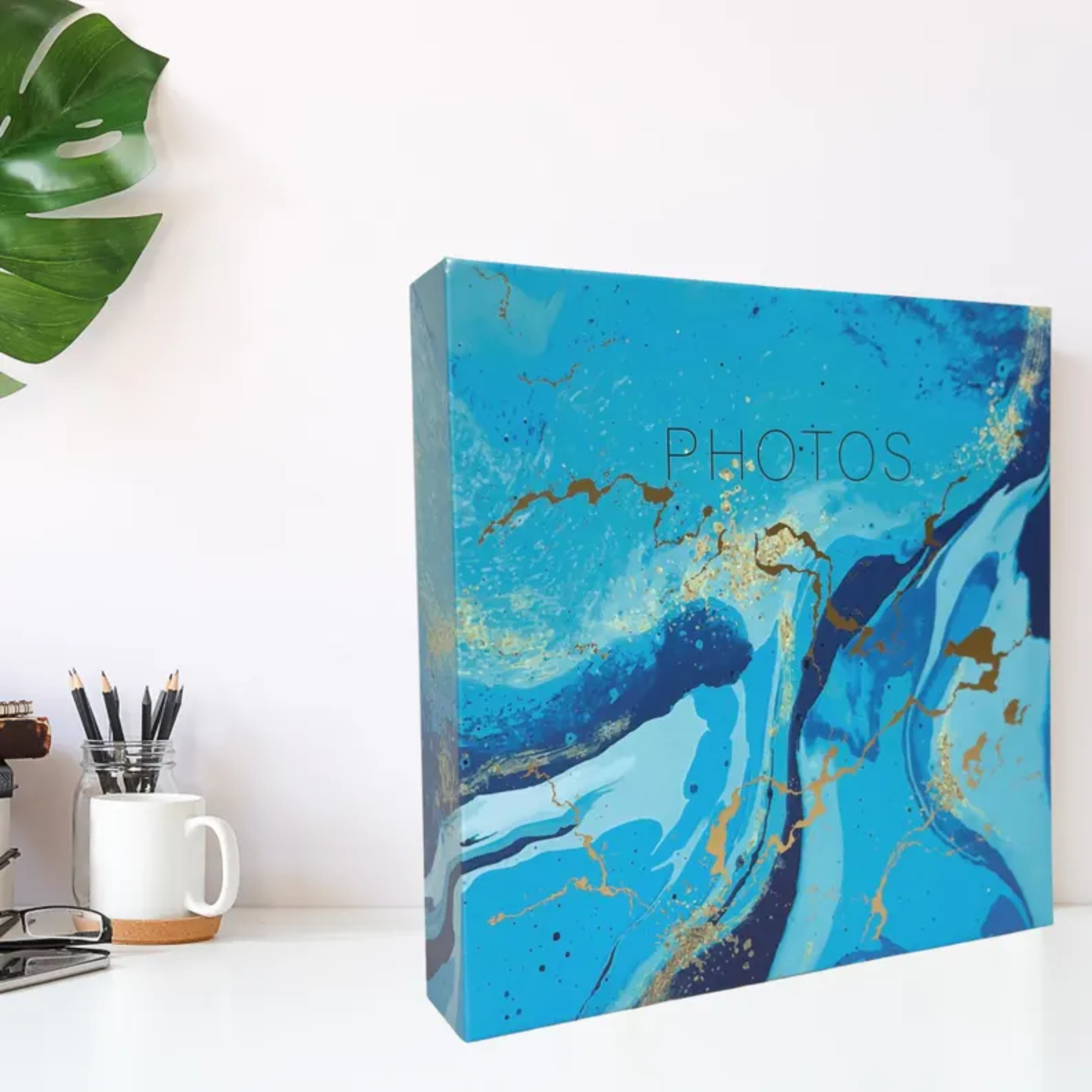Blue marbled photo album on a desk with office supplies in the background