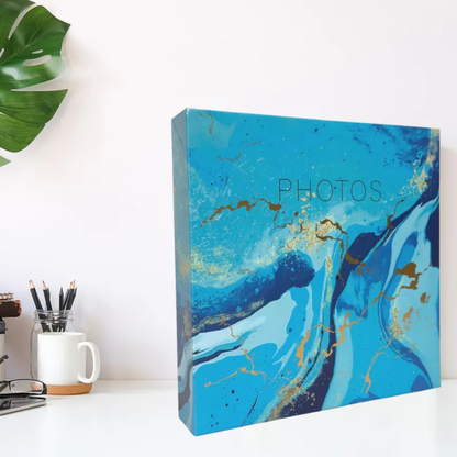 Blue marbled photo album on a desk with office supplies in the background