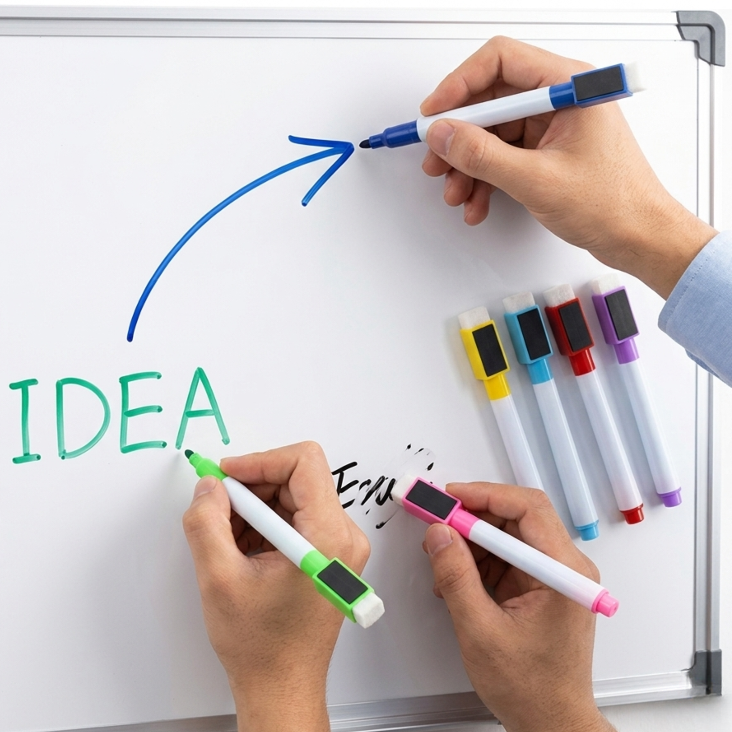 Hands writing 'IDEA' on a whiteboard with colorful markers.