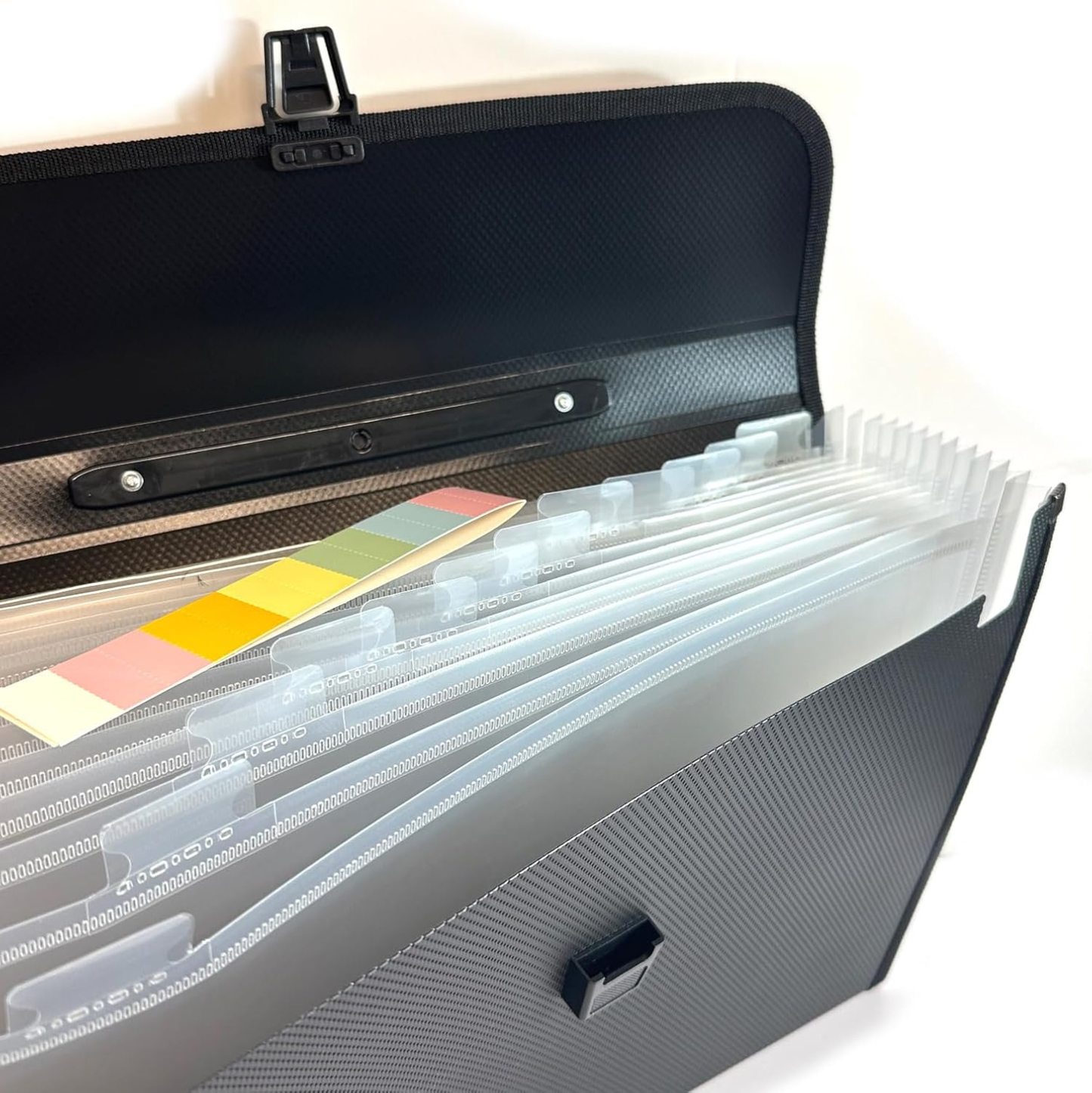 A black textured file organizer case shown open, revealing translucent plastic divider sleeves and colorful paper tabs inside.