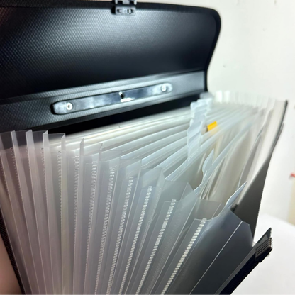 A black textured file organizer with multiple translucent plastic hanging folders attached, shown open against a plain light background.