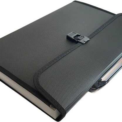 A black textured hardcover notebook or journal with a black elastic closure strap and metal clasp, shown on a plain white background.